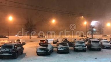 傍晚，在大雪下，<strong>汽车</strong>在灯光下缓慢地沿着道路<strong>行驶</strong>。 白雪覆盖的<strong>汽车</strong>停在停车场。